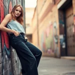 Showcasing stylish baggy black jeans in a vibrant urban backdrop, highlighting street fashion.