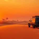 Experience the thrill of an evening desert safari dubai with a 4x4 navigating golden dunes at sunset.